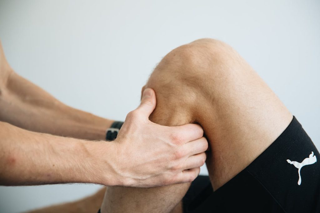 A man is doing a knee massage on a patient